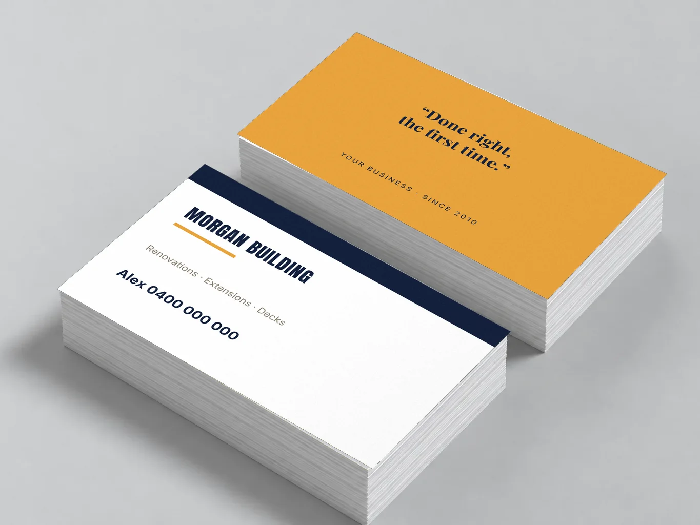Mockup of two stacks of amber builder business cards, front and back