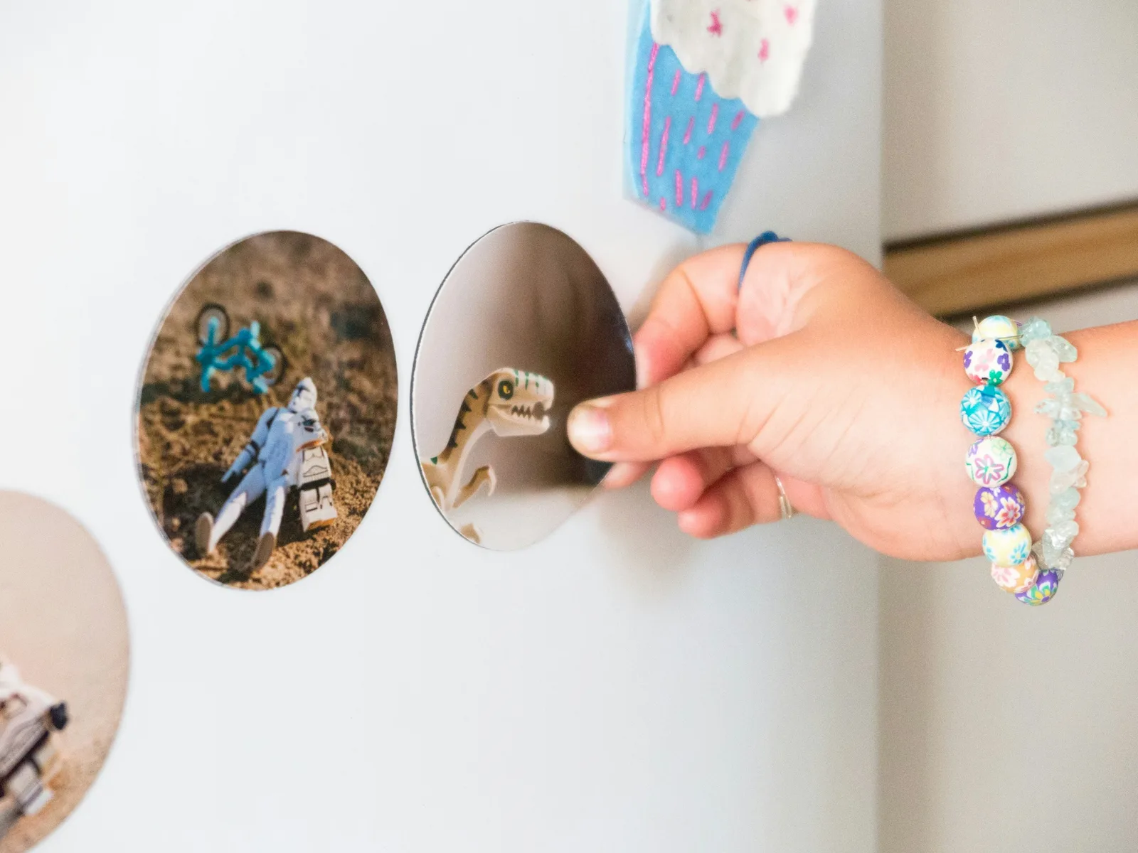 A hand placing a round printed magnet on a fridge