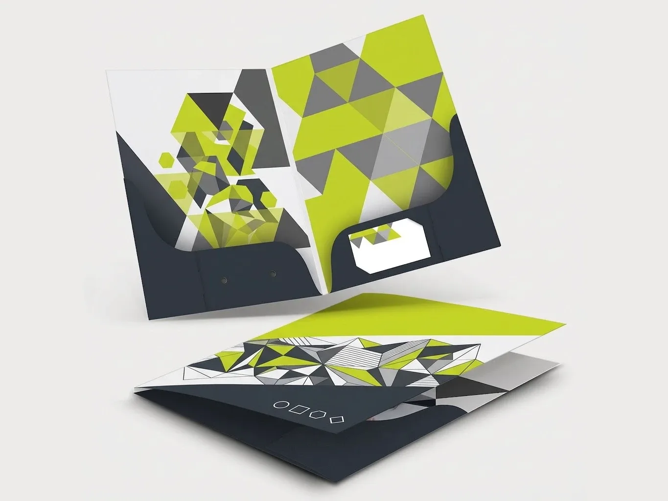 Mockup of two presentation folders in lime, grey and charcoal geometric artwork, one open to show the glued pockets and a business card slot, one closed