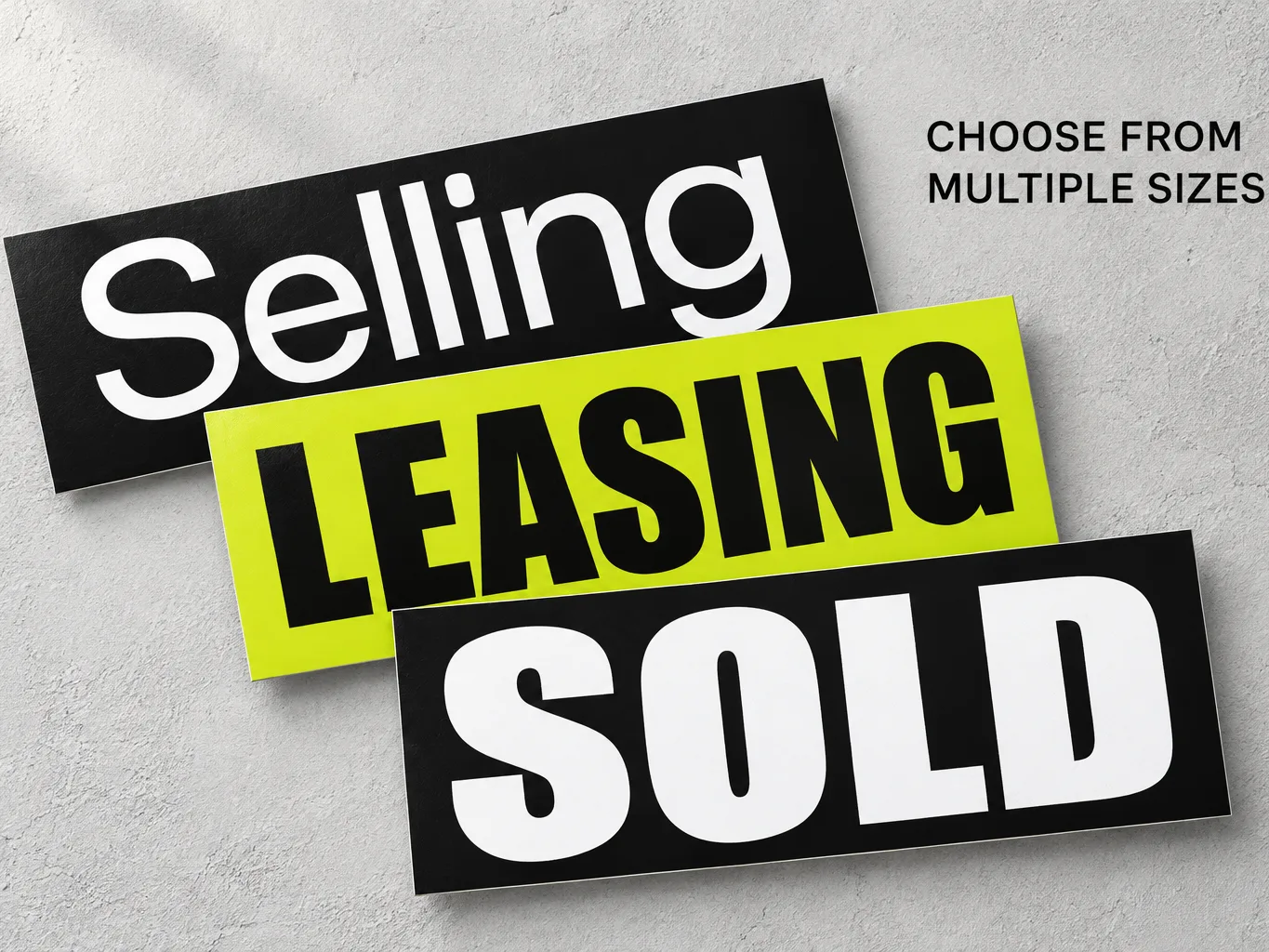 Mockup of three real estate stickers reading Selling, Leasing and Sold, in black and lime