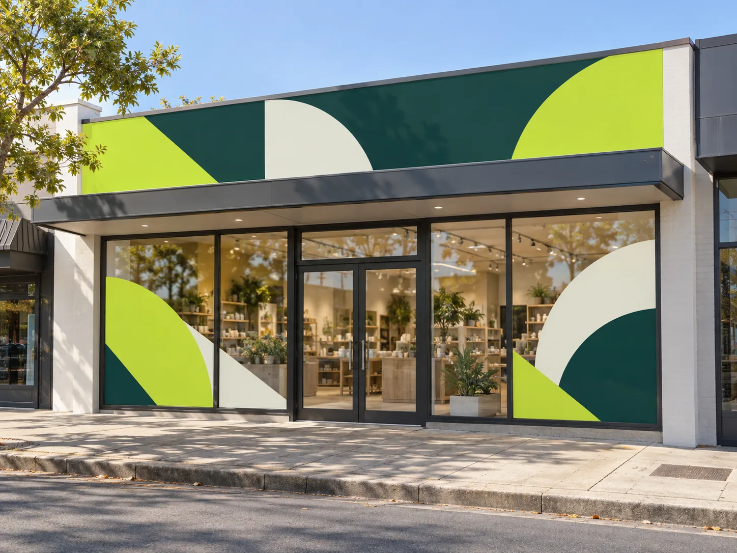 A shopfront with large geometric graphics in lime, deep green and cream across the fascia band and the windows either side of the door
