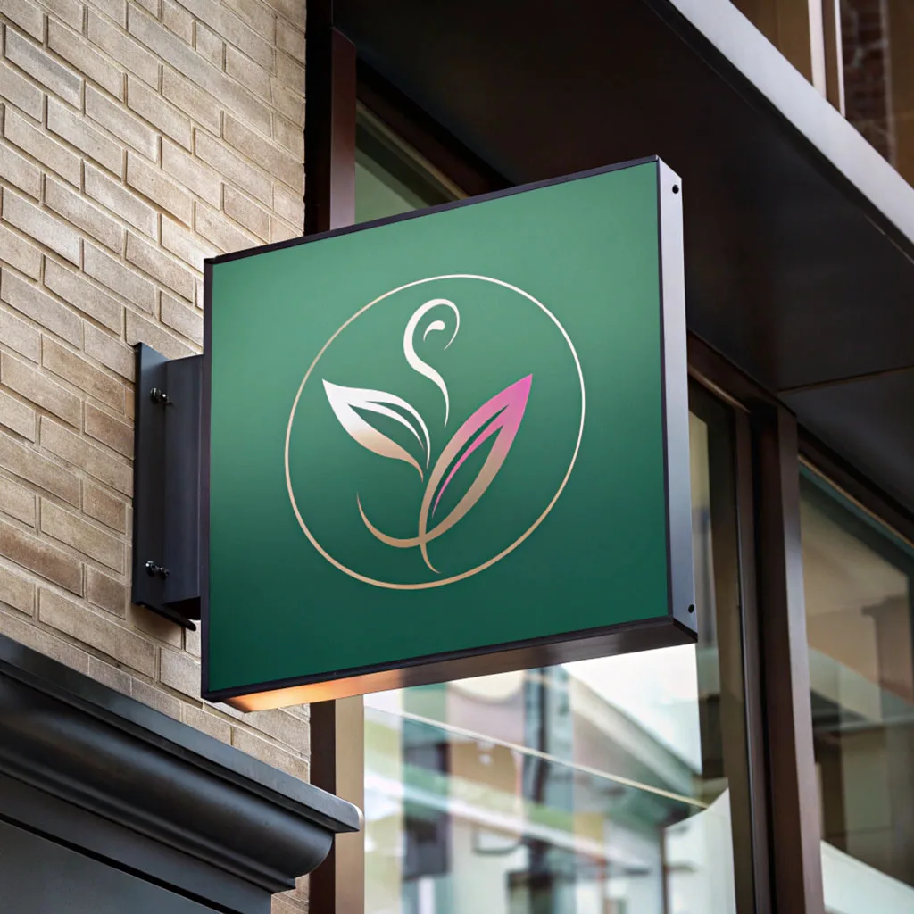 A green projecting shopfront sign carrying a gold and pink botanical mark, wall-mounted on brick above a shop entrance