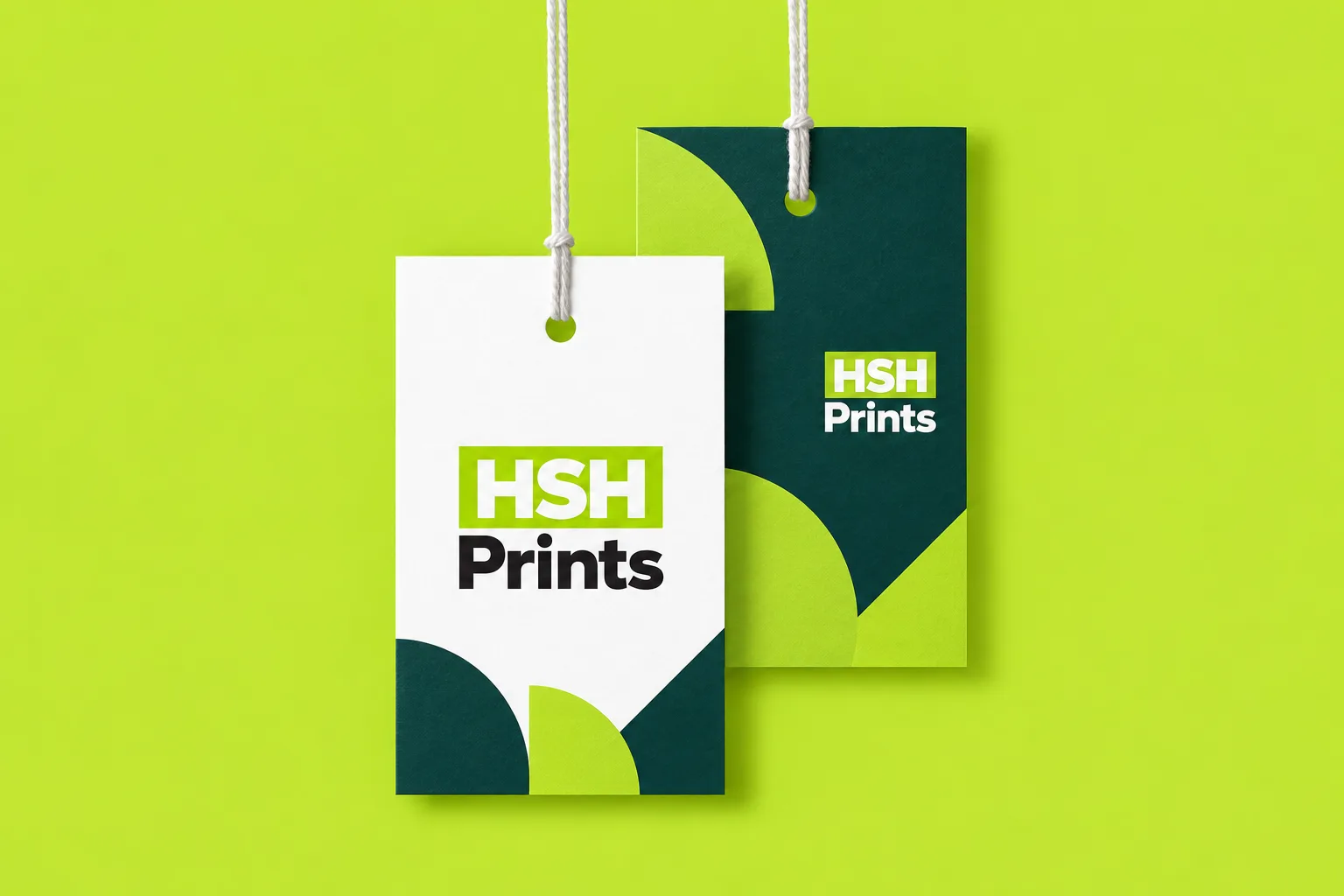 Two HSH Prints swing tags on white strings against a lime background, one white with a green geometric foot, one dark green