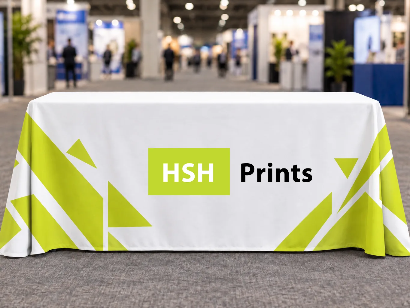Mockup of a white and lime HSH table throw on a trestle table in an expo hall aisle