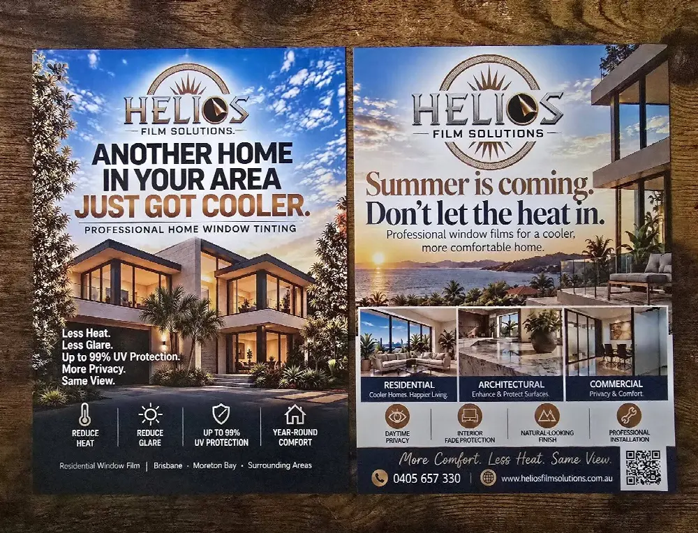 Two printed flyers on a timber table for a home window tinting business: one headed Another home in your area just got cooler, the other Summer is coming, don't let the heat in.